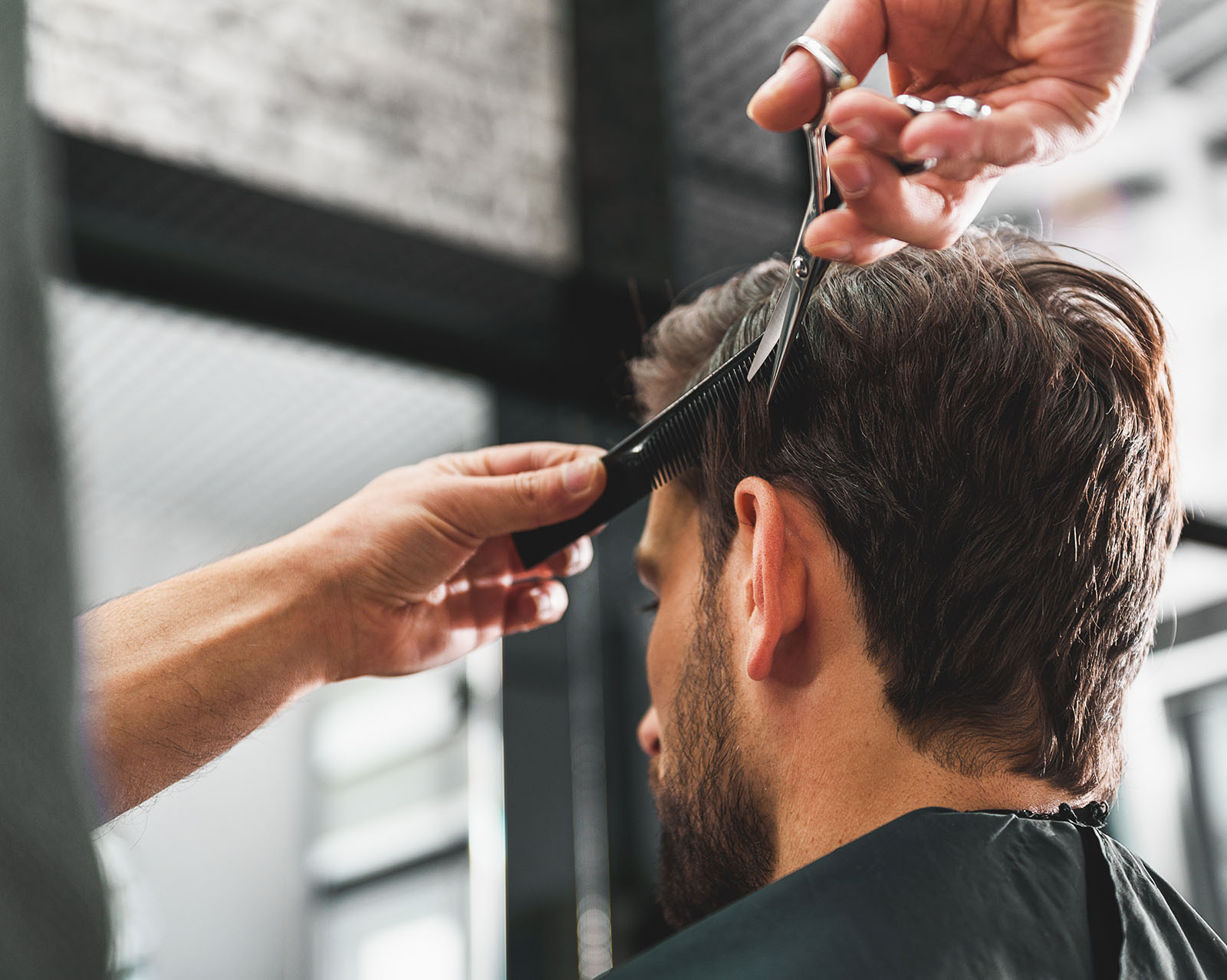 Herrenhaarschnitt Herrenhaarschnitt, Blick auf Hinterkopf von Mann mit braunen kurzen Haaren, dem gerade die Haare geschnitten werden, Friseur Salon Julia